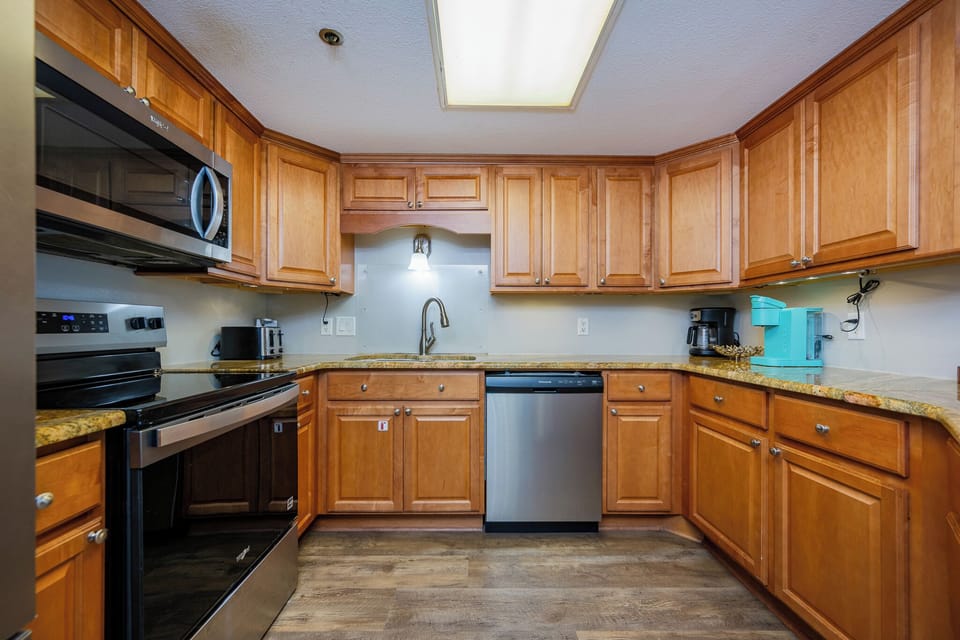 Warm wood cabinets surround your kitchen where the aroma of fresh coffee fills the air from the Keurig or coffee maker
