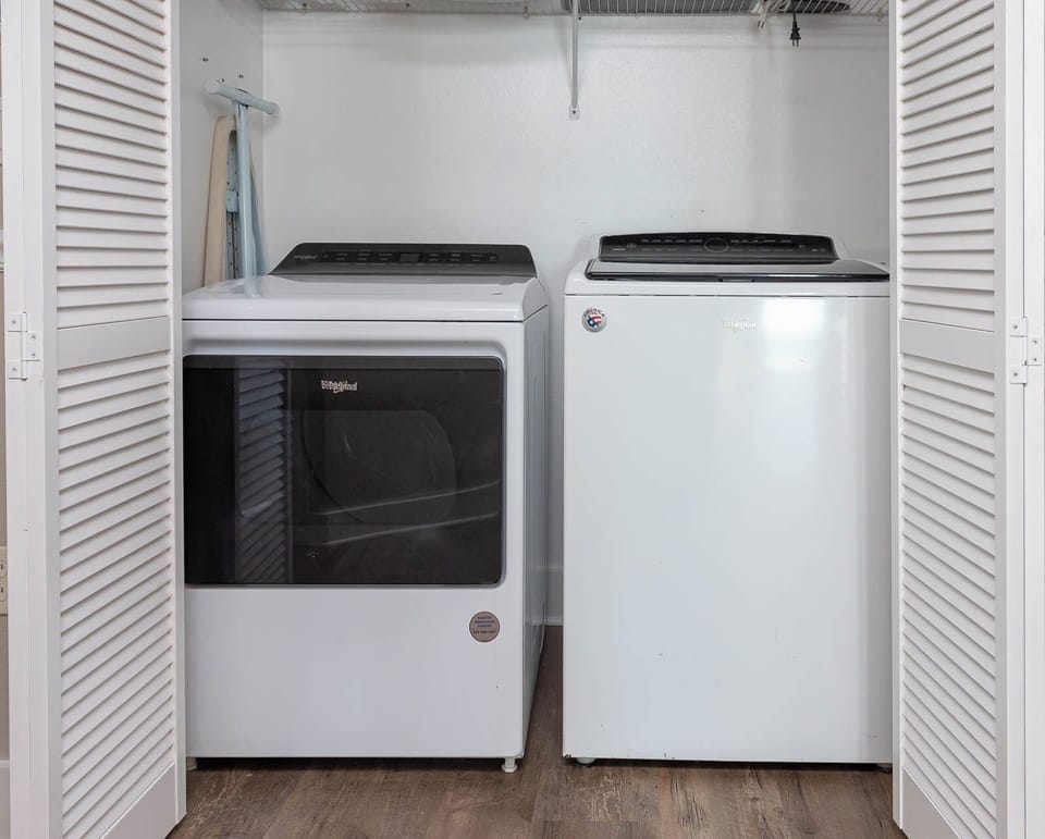 Laundry area featuring a washer and dryer behind louvered doors, providing convenience for guests during their stay