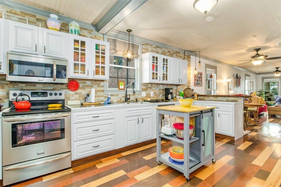 Chef-friendly kitchen with breakfast bar seating, reclaimed wood backsplash, and full-size appliances