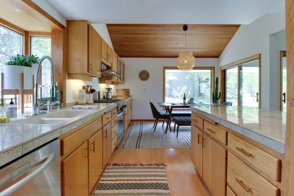 The kitchen features stainless steel appliances and a complete array of cookware