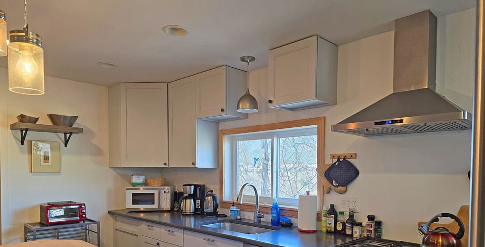 Fully equipped modern kitchen with cookware, utensils, spices, and oils for easy meal preparation.