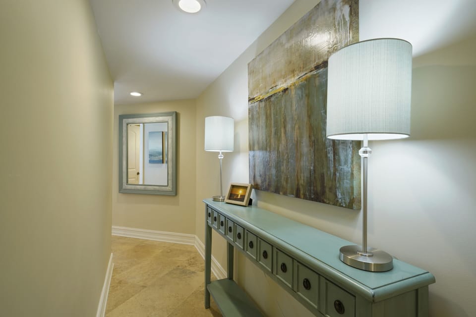 The thoughtfully decorated entryway offers a clean, airy feel with upscale finishes and beach-inspired accents.