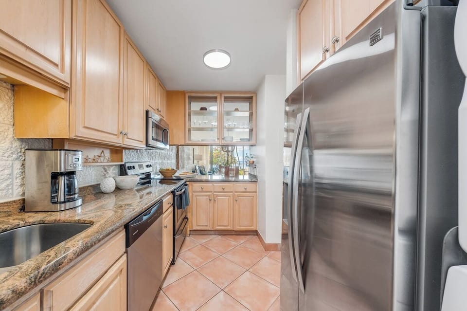 Fully equipped kitchen featuring stainless steel appliances, ample counter space, and an open layout ideal for preparing meals during your Maui stay.