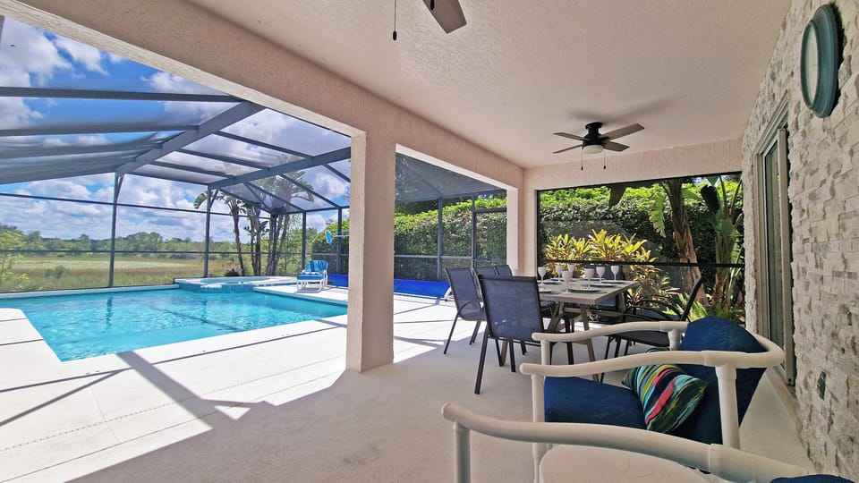 Screened lanai with seating by the pool