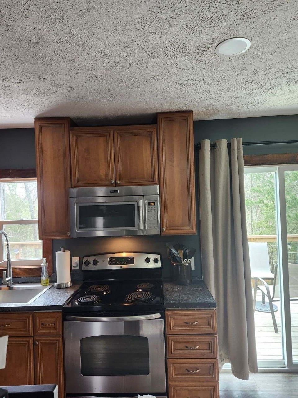 Stainless steel electric stove and full-size microwave.