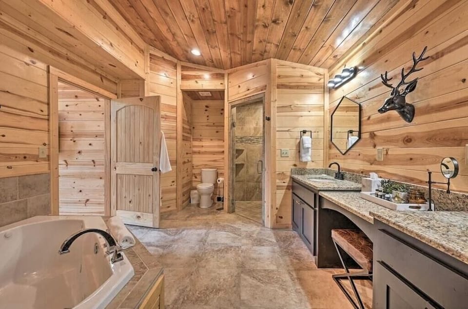 Primary full bathroom with jetted tub for two, stand up rain double shower head and toilet