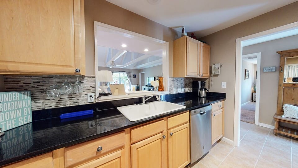 The kitchen offers generous prep space, stainless steel appliances, and an open pass-through to the living area—keeping the cook connected while meals come together with ease.