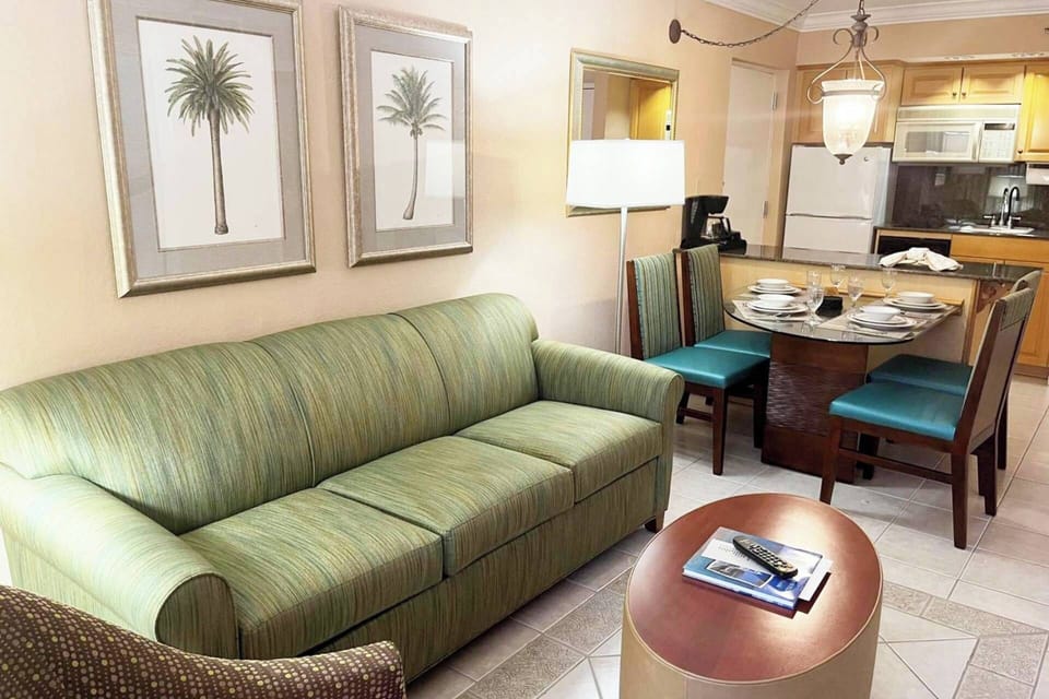 Living room features a sleeper sofa. Separate dining area has a table for 4.