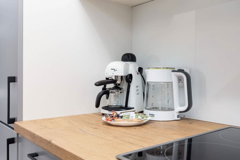A compact dining table with a coffee maker and cups for morning convenience.

