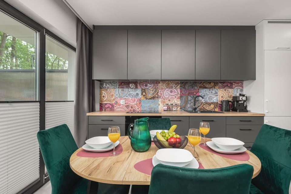 A vibrant kitchen and dining area with colorful patterned walls and a modern layout.


