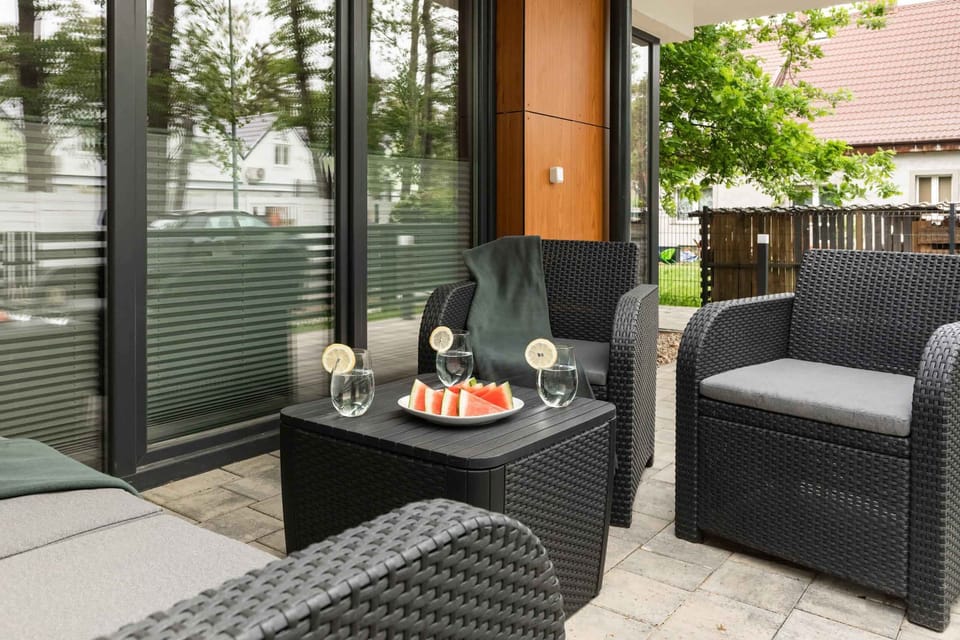 An outdoor seating area with elegant wicker furniture, perfect for enjoying a morning coffee or relaxing in the fresh air.

