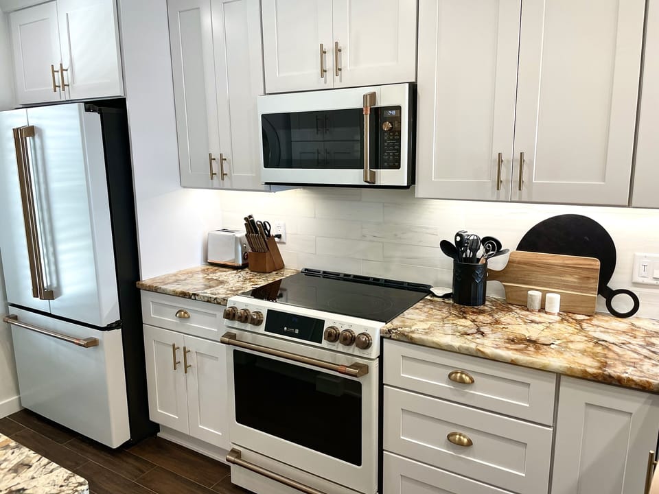 Luxury GE Cafe appliances, white craftsman cabinets & brushed bronze hardware.