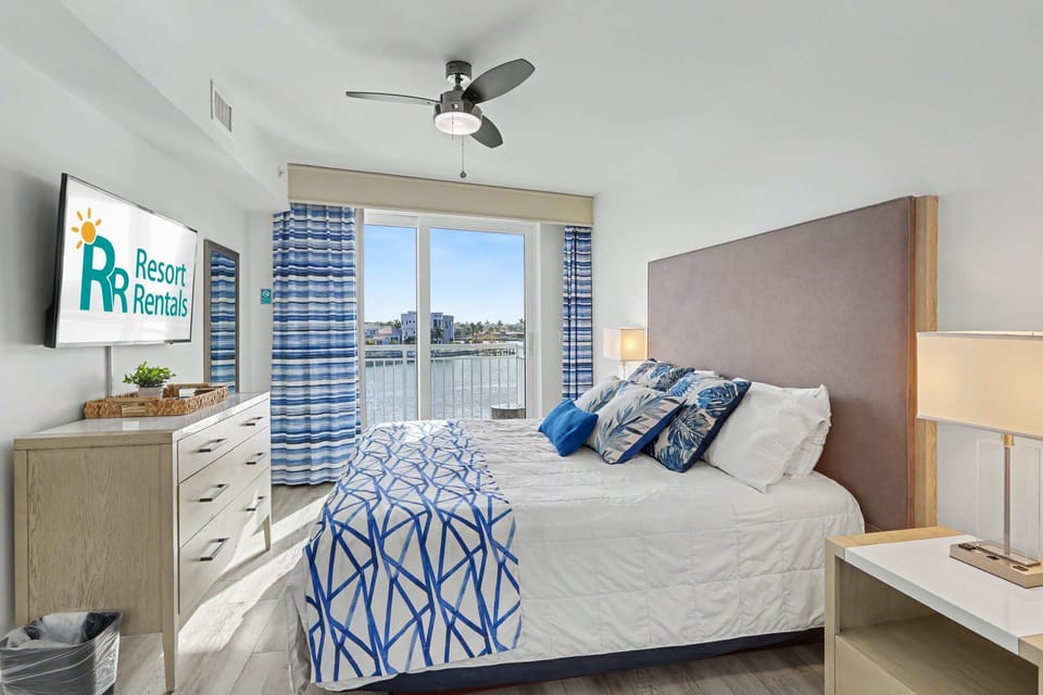 Master bedroom - king bed, TV, and private balcony access