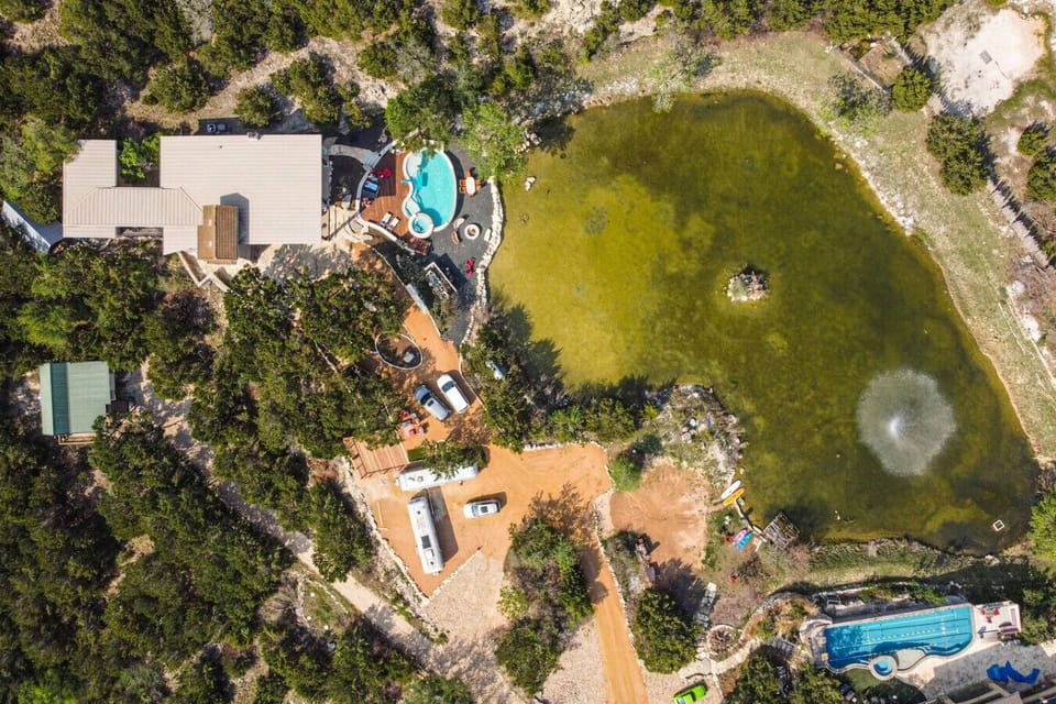 Five private acres! Spring fed pond! Two homes and three cabins! Sleeps up to 25!