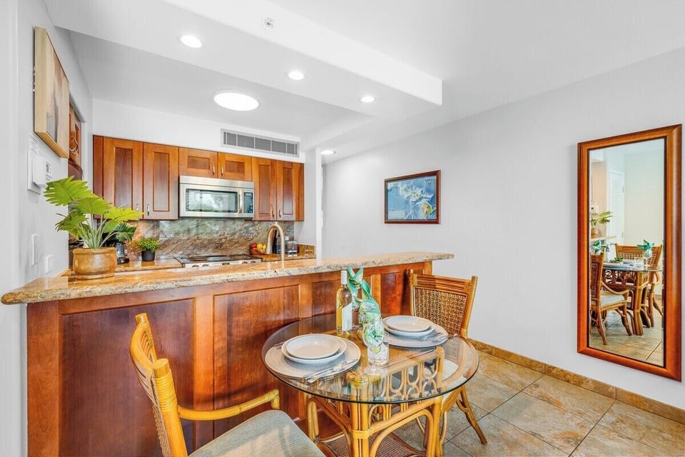Charming dining space with a glass-top table and rattan chairs, perfectly positioned near the fully equipped kitchen