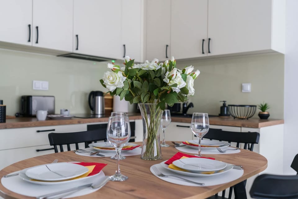 A well-equipped kitchen and dining area with elegant tableware and fresh blooms.

