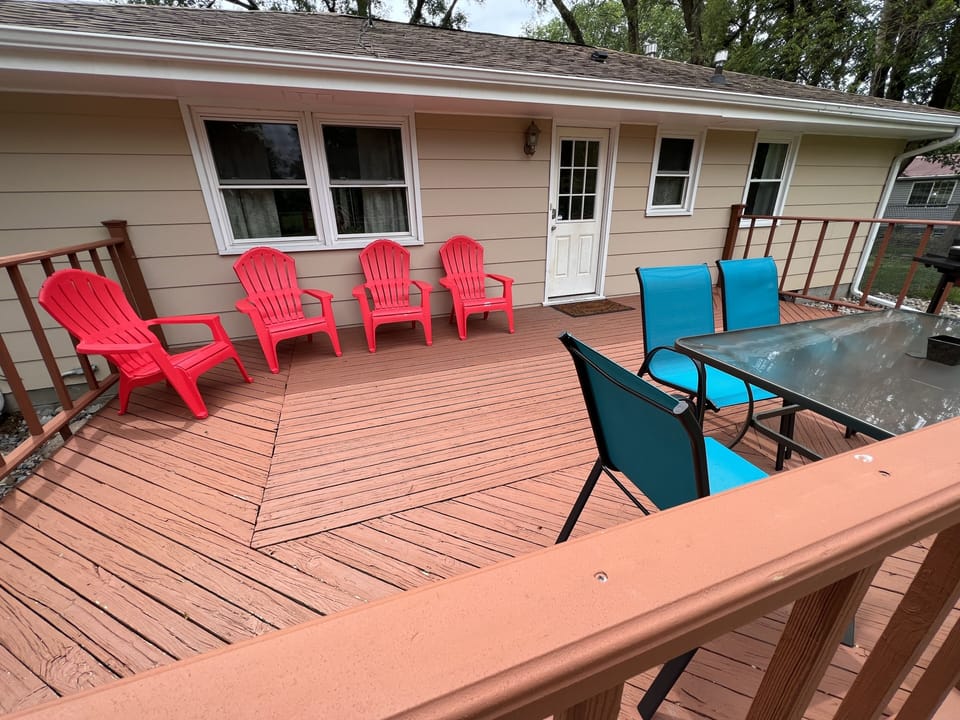 Large deck with seating overlooking the oversized, fenced in backyard. 
