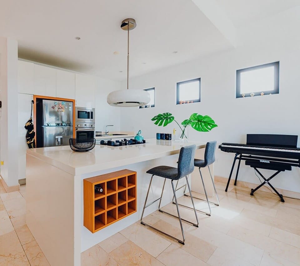 A fully equipped kitchen with built-in wine rack and extra bar table seating, coffee machine, oven and microwave with all kitchen utensils. 
