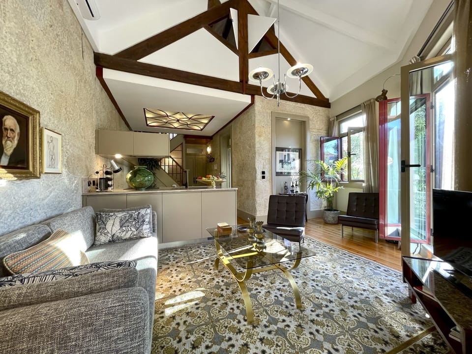 Double height living area with its old wooden structure and opening shutters 