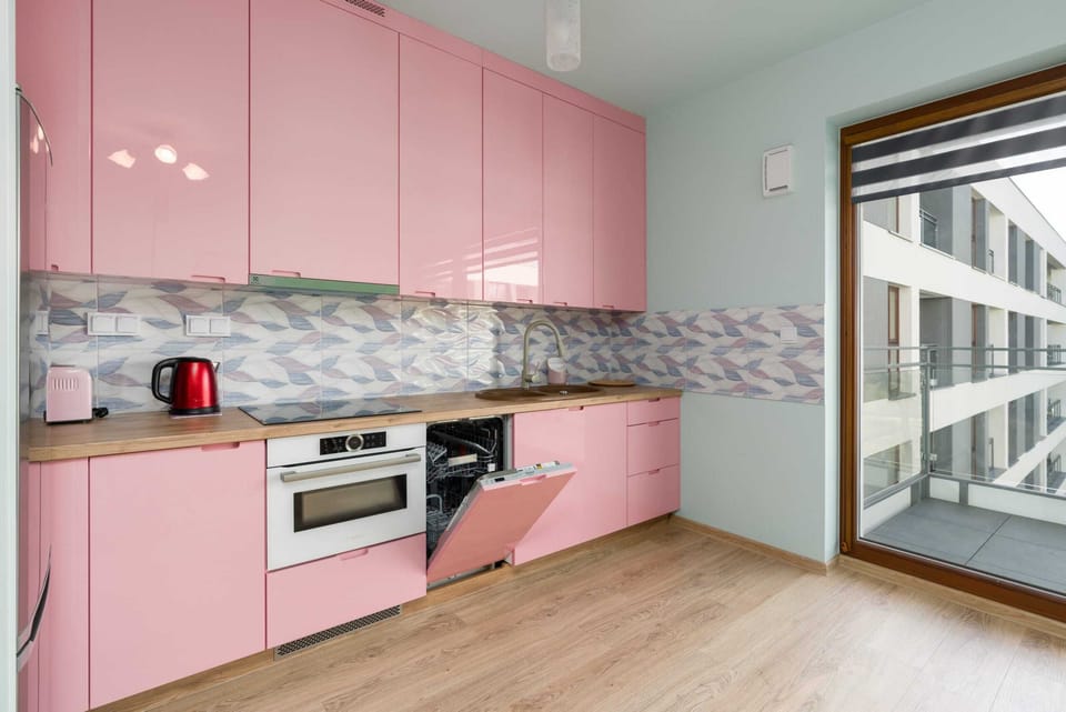The full view of the pink kitchen, blending functionality with a unique style.
