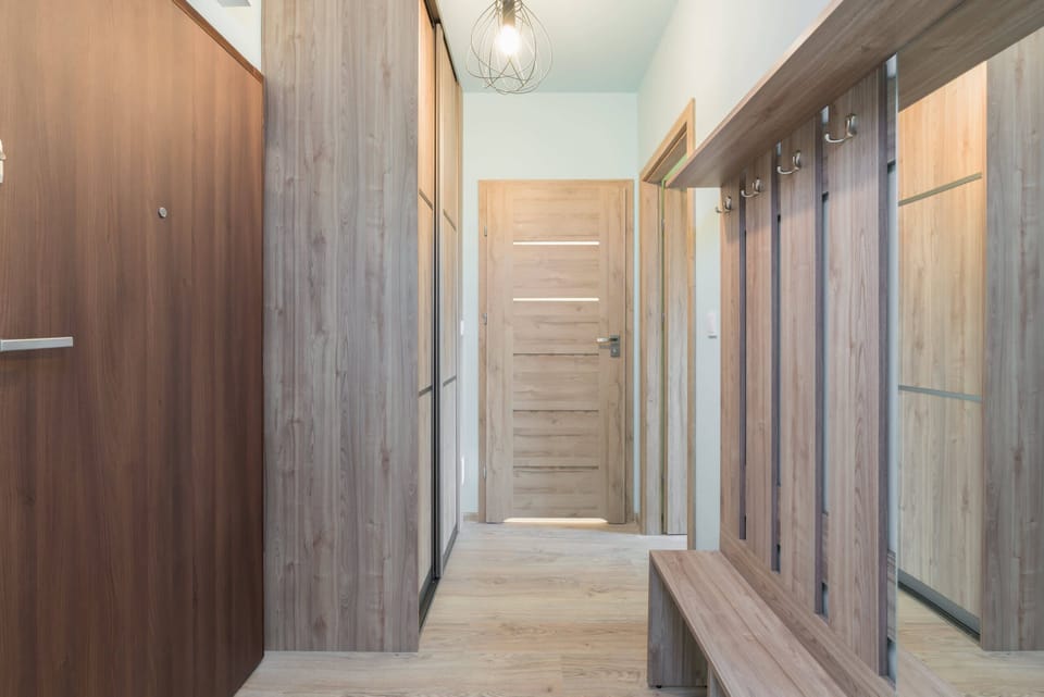 A well-lit entryway with ample storage space and a wooden bench.
