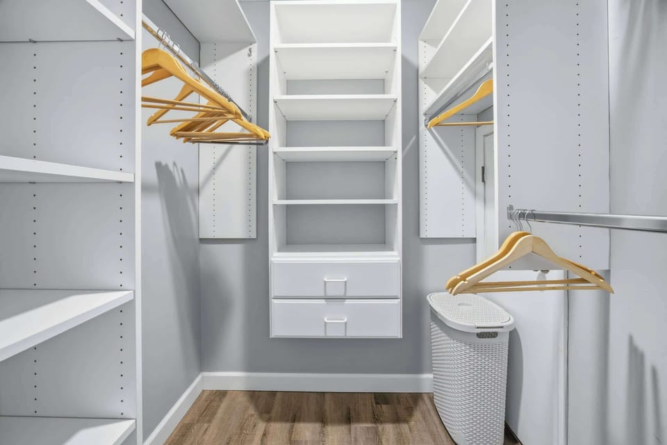 Organized walk-in closet with ample shelving and hanging space