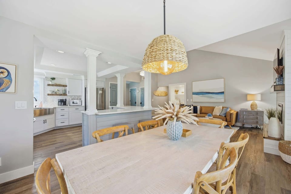 Open-concept dining and living area with coastal-inspired decor and natural light