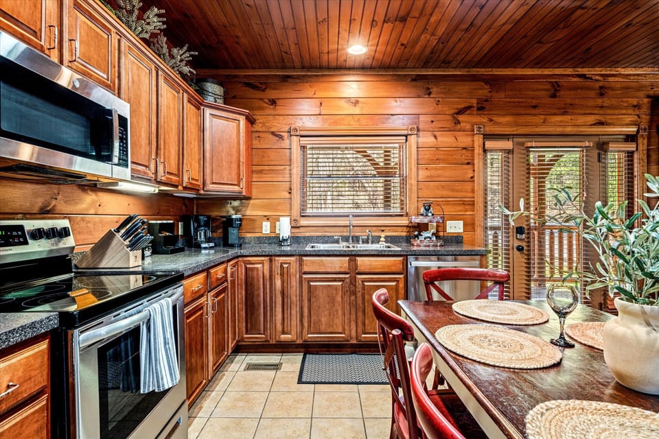 Another angle showcasing wooden cabinets, modern appliances, and charming décor, creating a warm and inviting cooking space.