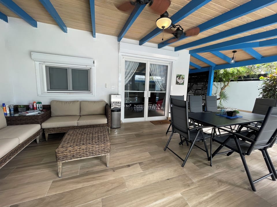 outdoor living and dining room with a water dispenser, steps to the pool
