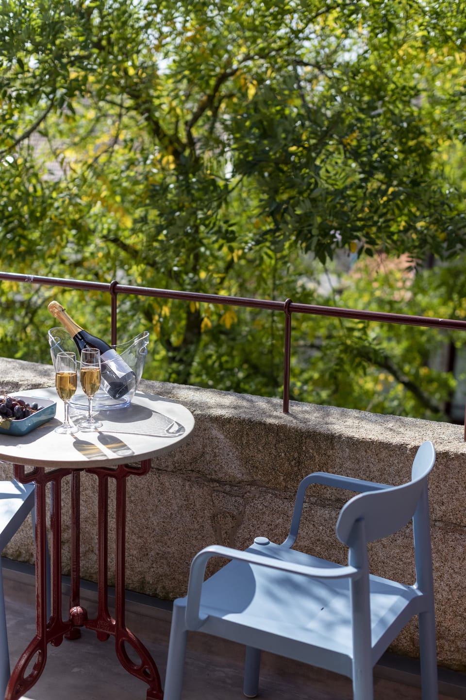 Sunny balcony on the top floor of the building facing the tall trees 