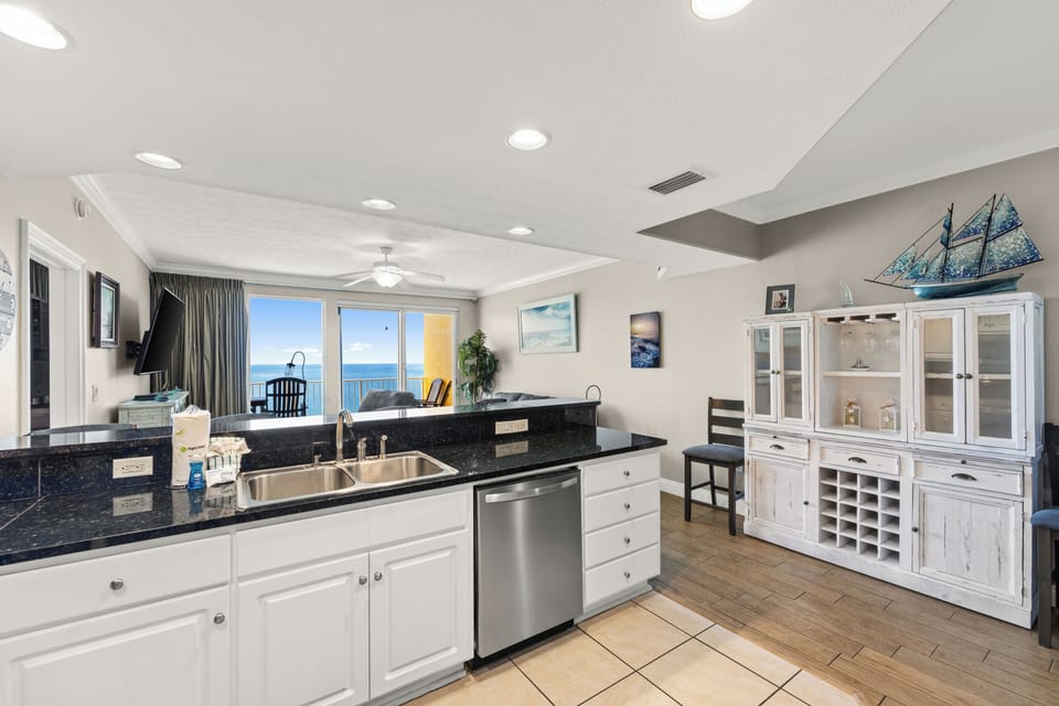 Bright, fully-equipped kitchen featuring polished granite counters, stainless-steel appliances, and nautical-inspired decor, with sweeping ocean views to set the tone for your beachfront escape.