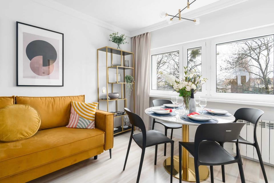 A mustard-yellow sofa paired with a dining table, adding a warm and inviting vibe.

