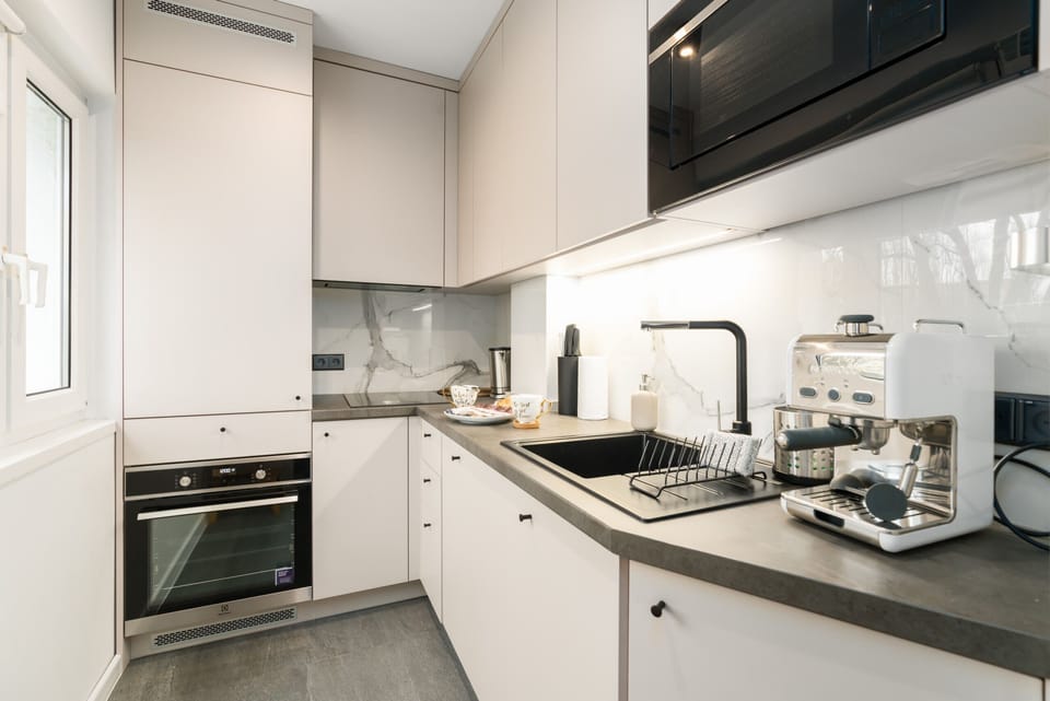 A sleek and fully-equipped kitchen with contemporary fittings and appliances.

