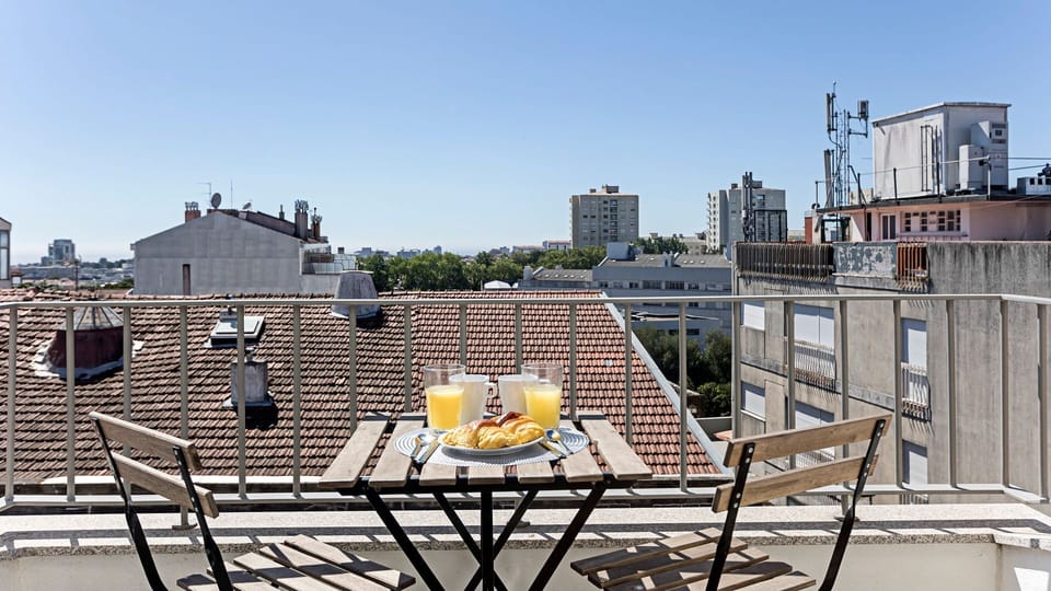 Enjoy an alfresco breakfast or an evening drink on your private balcony, offering panoramic city views that stretch across picturesque rooftops. This inviting outdoor space is perfect for unwinding and savoring the ambiance of Porto. #PrivateBalcony #AlFr