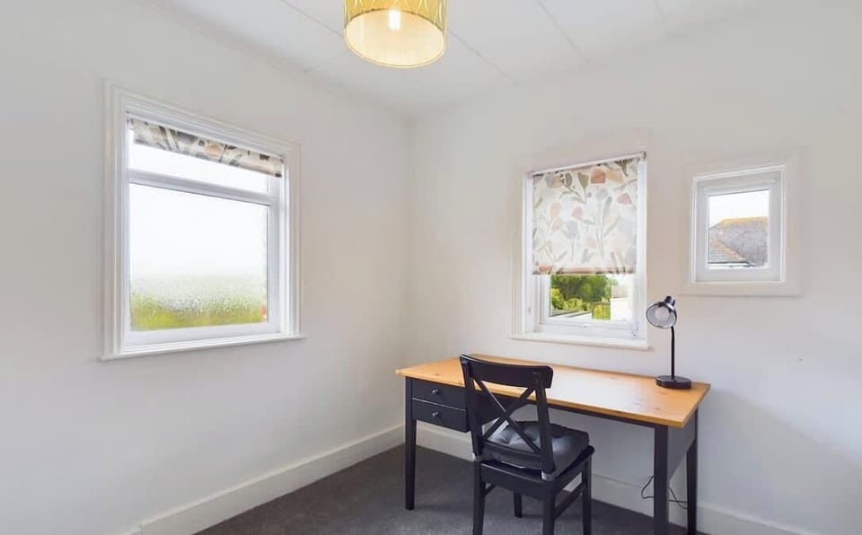Upstairs office space at East View with desk and stunning views across Culver Down, ideal for remote working or quiet time.
