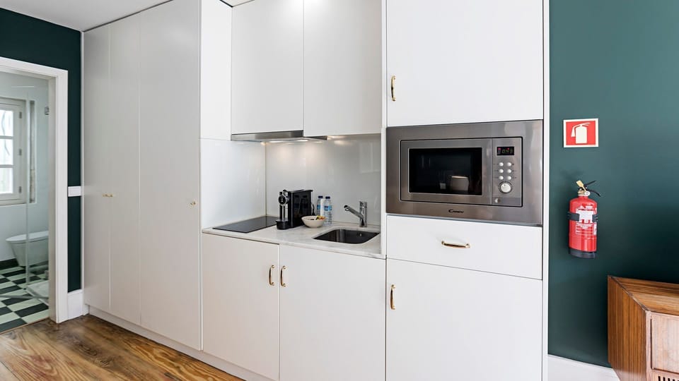 This lovely kitchenette is equipped with many appliances, such as a microwave, a stove top, a coffee machine, toaster and kettle, as well as all the basics like plates and silverware #simple #modern
