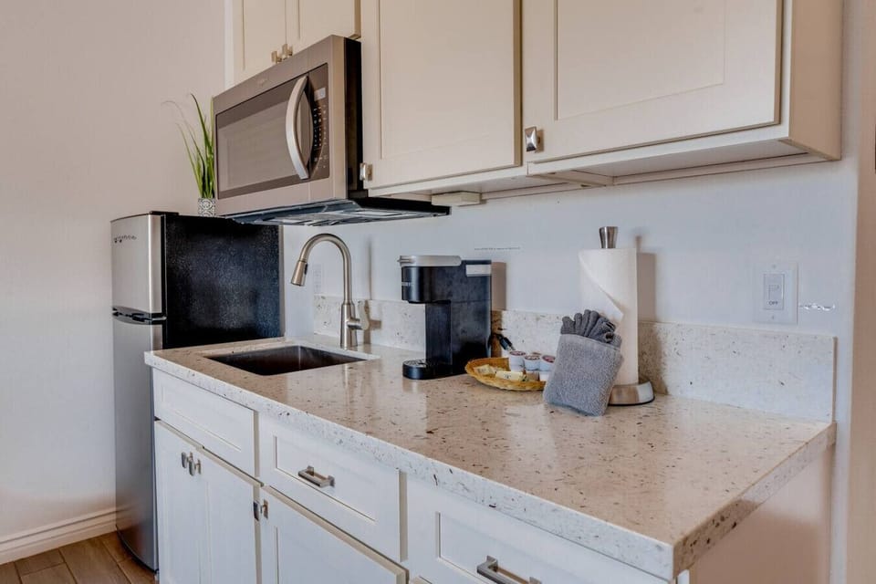 Kitchenette equipped with essential tools for preparing small meals. There is no stove or oven, but it includes a portable hot plate, skillet, and other basic cookware