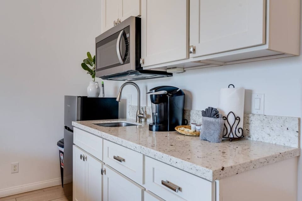 Kitchenette equipped with essential tools for preparing small meals. There is no stove or oven, but it includes a portable hot plate, skillet, and other basic cookware