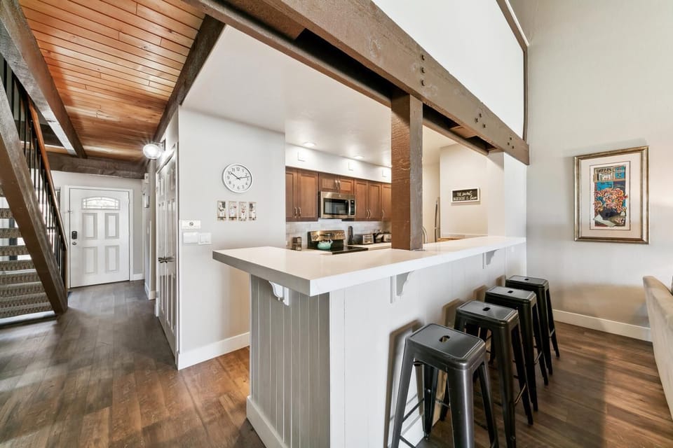 Your open kitchen invites gathering around the spacious island, where rustic beams blend with modern amenities for memorable meals together.