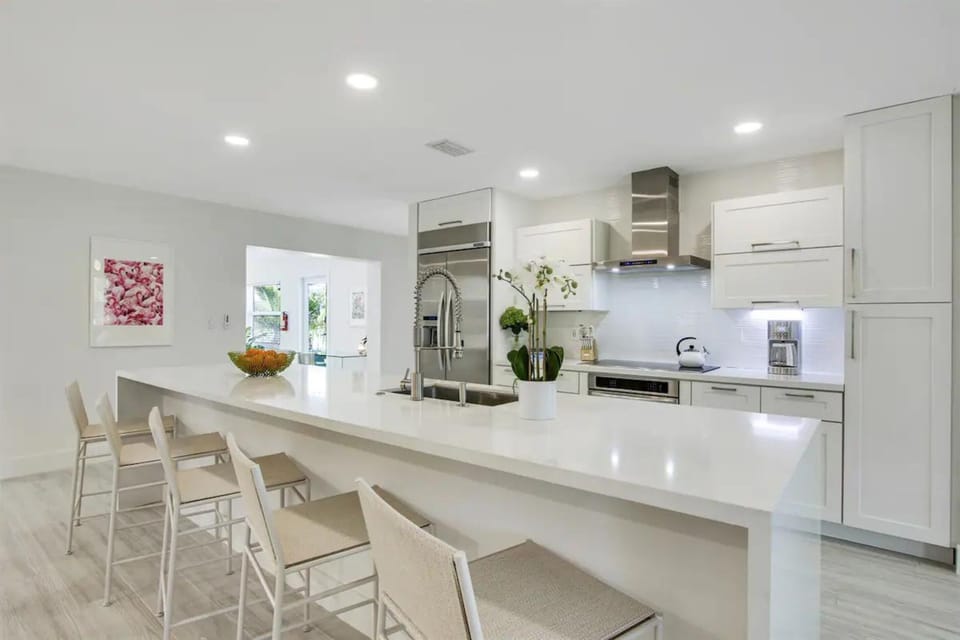 Indulge in our modern chef's kitchen, complete with a spacious island seating 5. Stainless steel appliances, including a double-door fridge and ice maker, set the stage for culinary excellence.