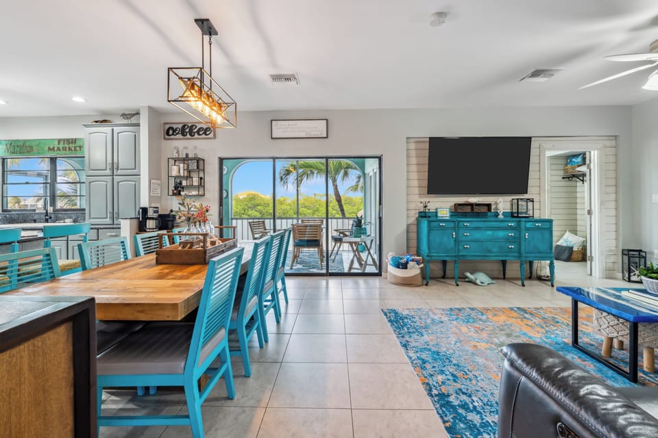 Open-concept living room with coastal decor and flat-screen TV in Marathon FL rental.