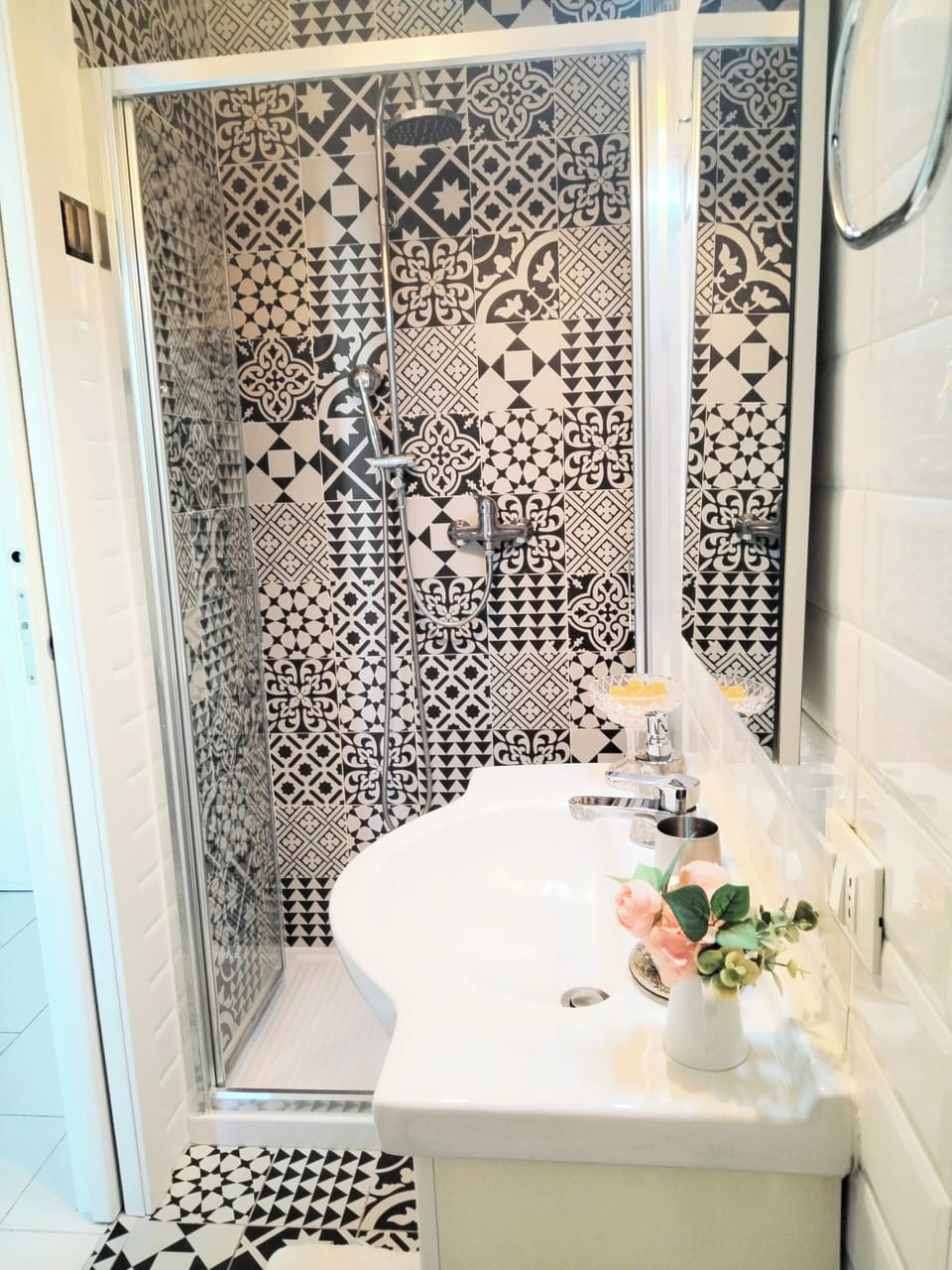 Bagno con lavabo, grande specchio e grande cabina doccia piastrellata 