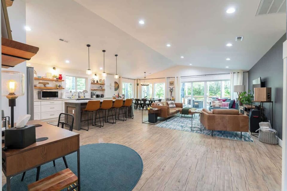 Here's a view of the great room from the front hallway. We have a chef's kitchen, seating to accommodate six at the dining table, a cozy living room area, and large sliding glass doors and windows that face the private backyard.