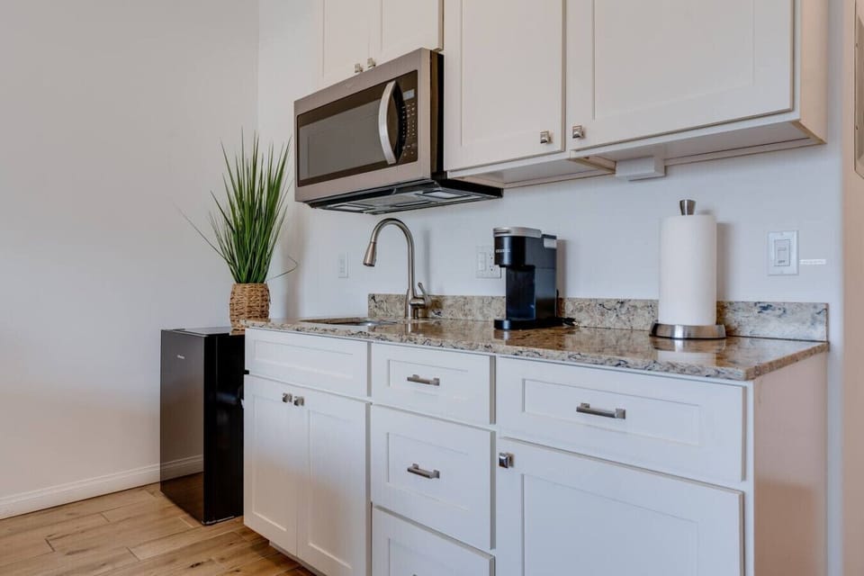 Kitchenette equipped with essential tools for preparing small meals. There is no stove or oven, but it includes a portable hot plate, skillet, and other basic cookware