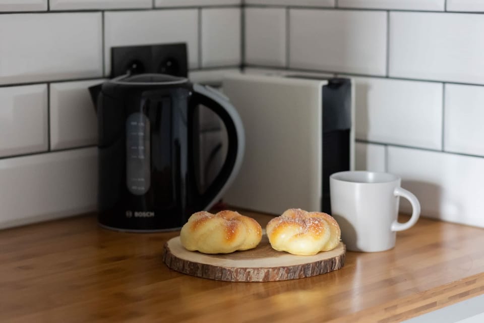 A neatly organized kitchen countertop with a coffee maker and breakfast pastries.

