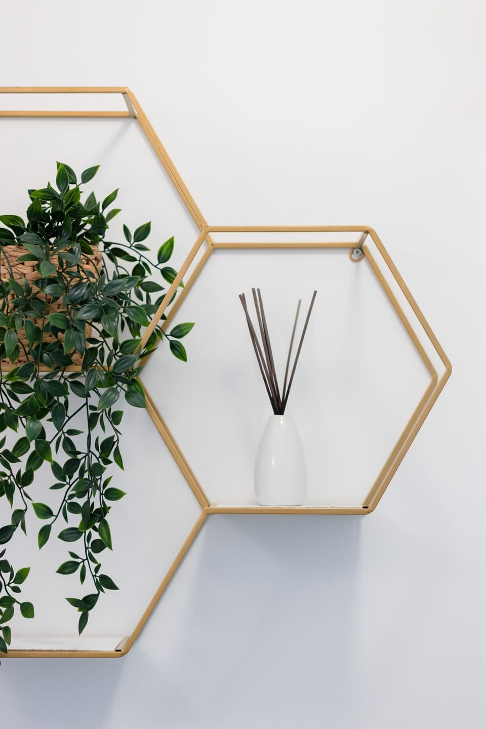 A decorative wall piece with geometric shelves and a plant, adding a modern touch to the bathroom.
