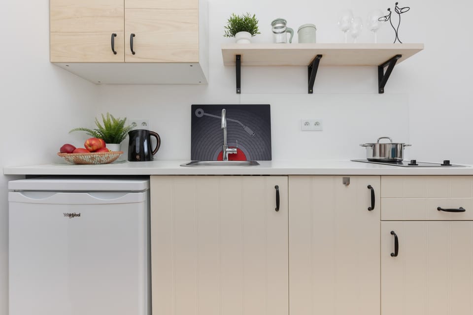 A kitchen area with sleek cabinetry, floating shelves, and thoughtful decor.
