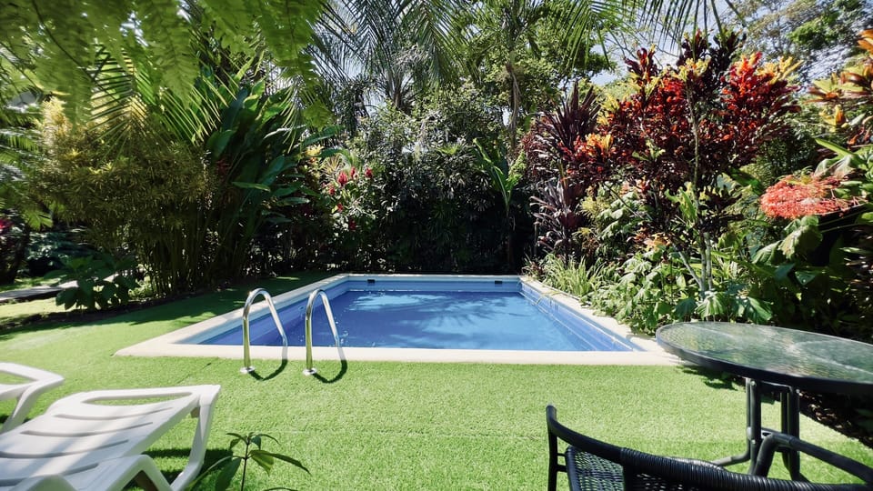 swimming pool area with chairs and table