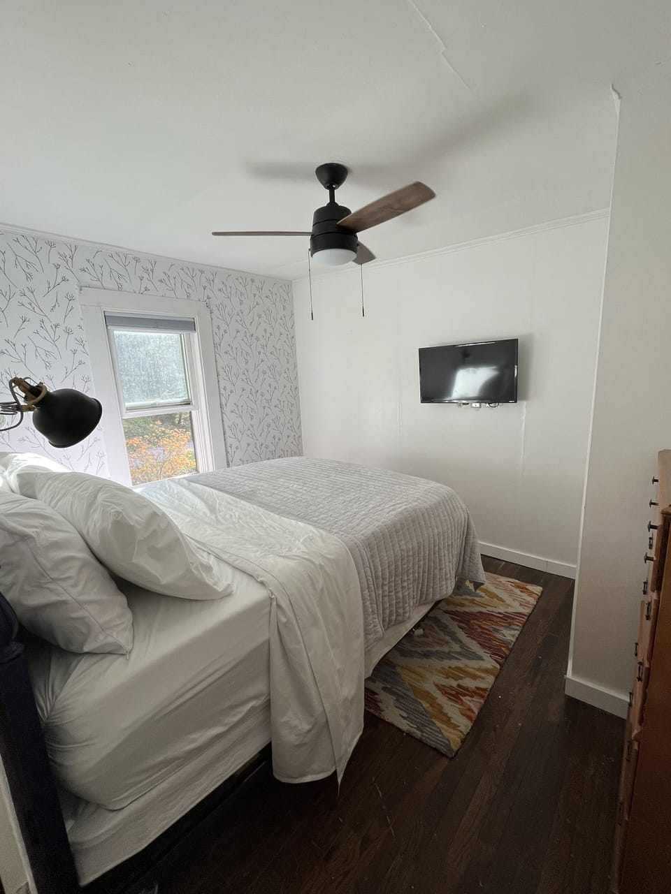 Queen bedroom with Smart TV, ceiling fan, and AC unit.
