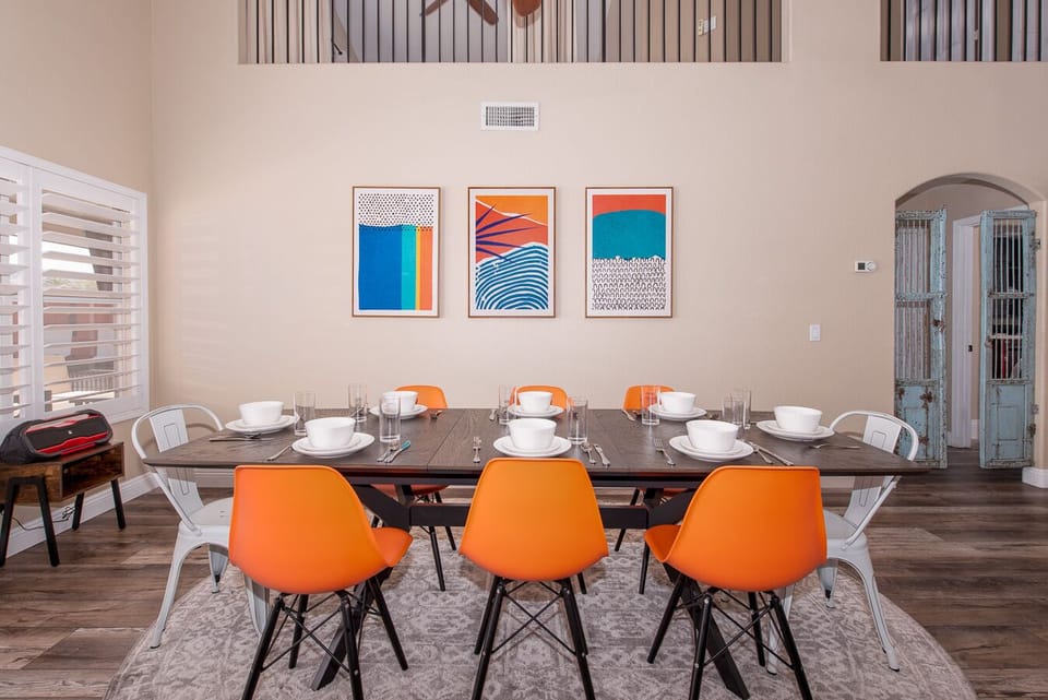 Dining room with desert mid-century modern decor has views of pool. Goodyear, AZ